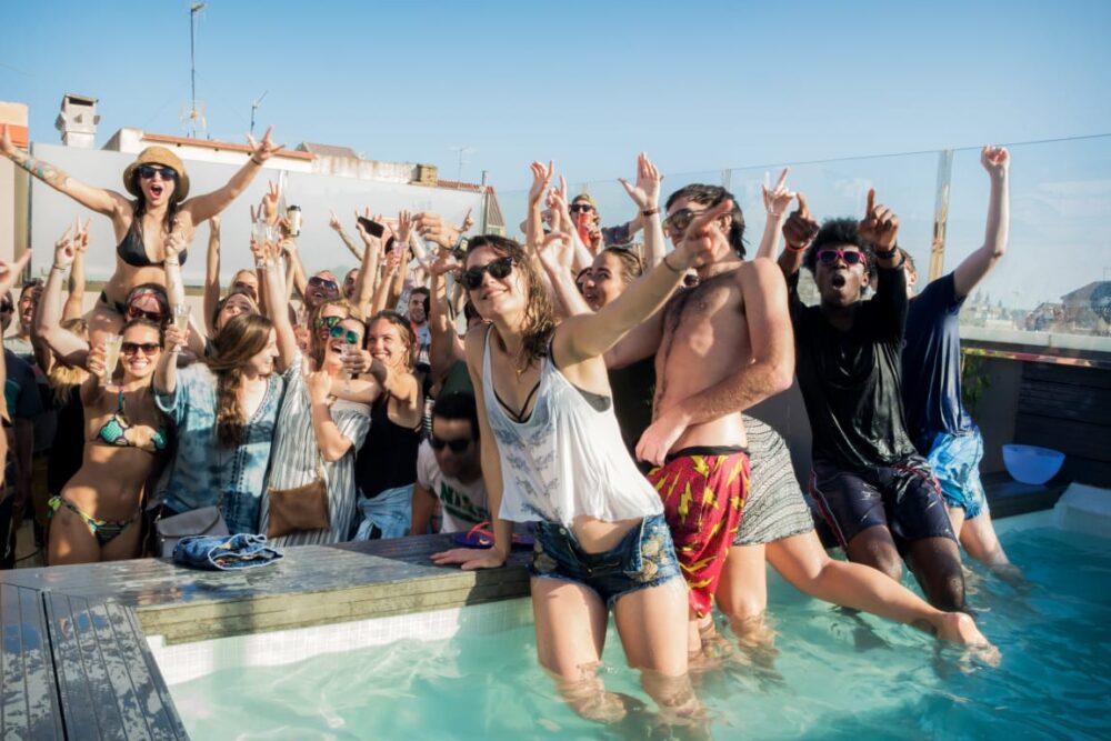 Jeunes faisant la fête au bord d'une piscine sur un rooftop