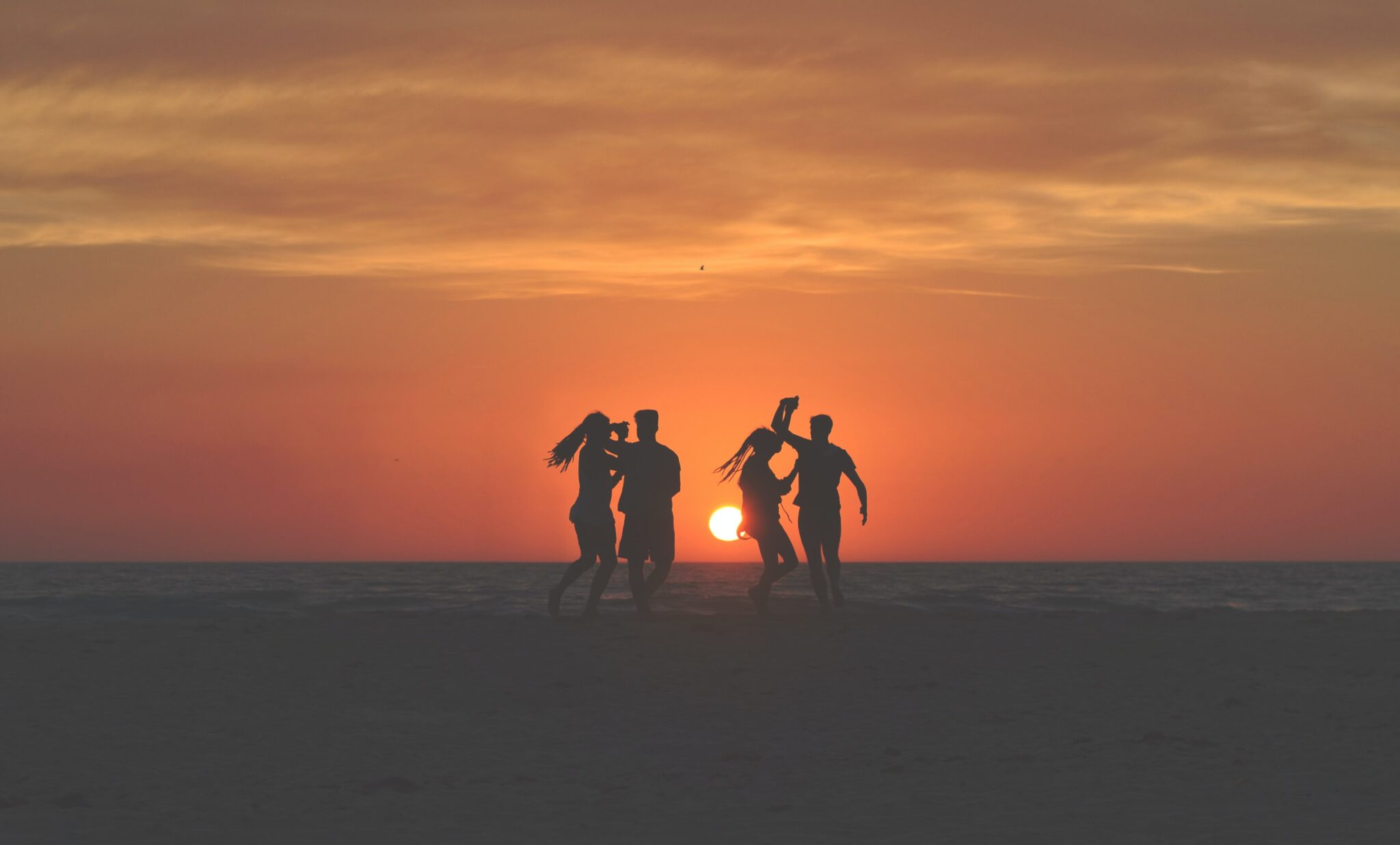 Gens qui dansent au coucher du soleil