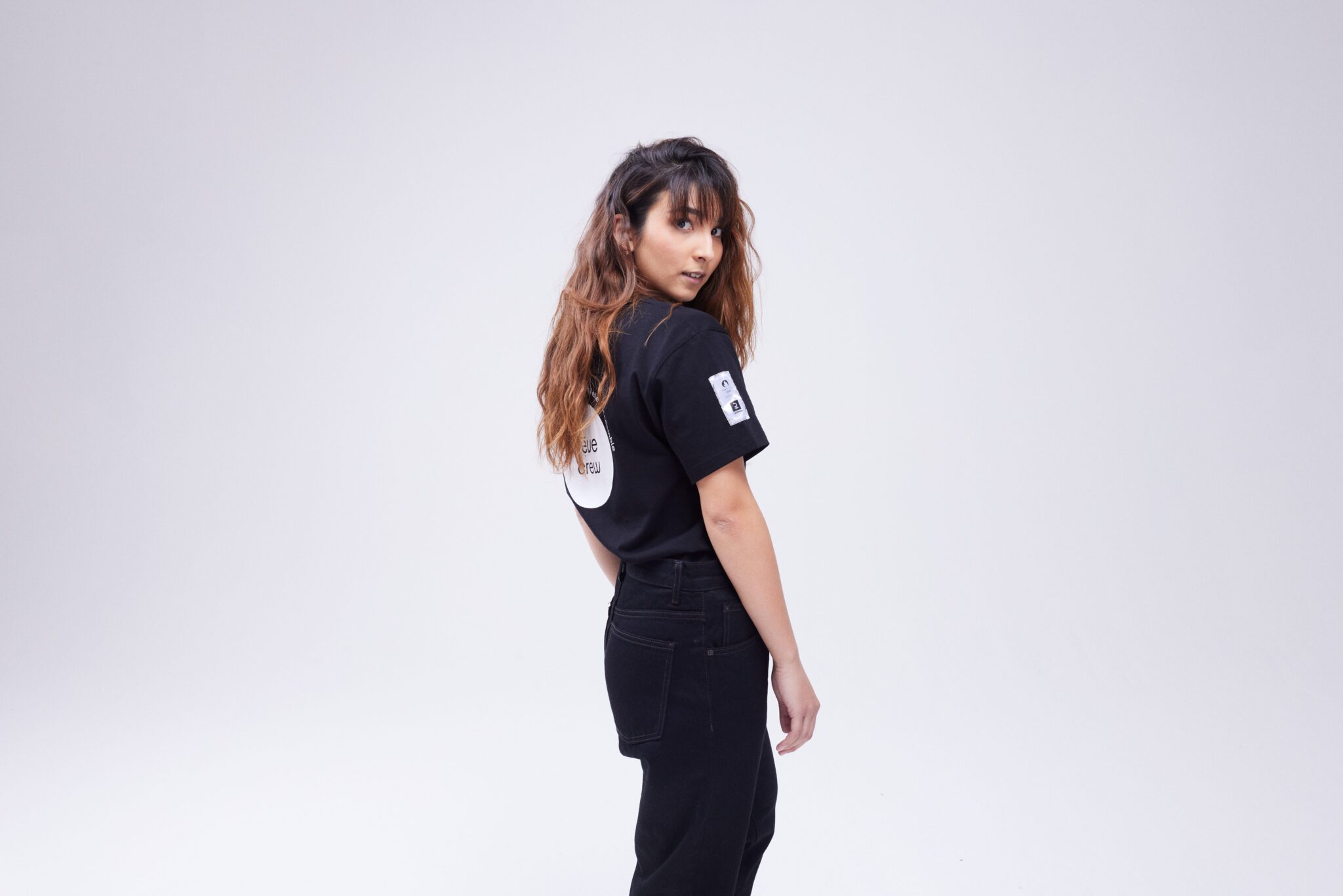 Photo Tijana Stojkovic de dos pour la nouvelle collection. Elle porte un t-shirt noir avec écrit Rêve Crew.