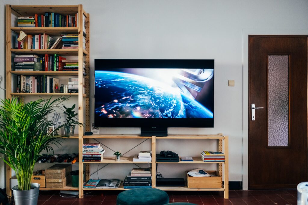 Télé allumée avec bibliothèque