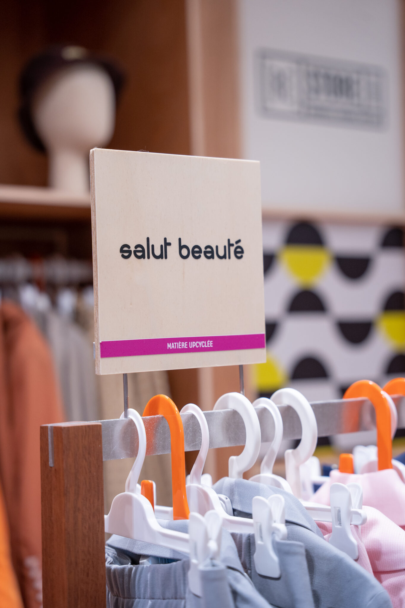 pancarte avec écrit "salut beauté" sur le portant de vêtements